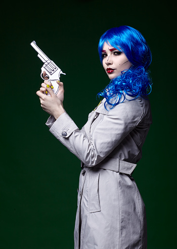 Portrait of young woman in comic  pop art make-up style.  Female with gun in hand.