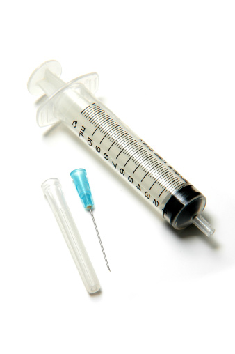 Syringe injection or medical needle isolated on green, selective focus