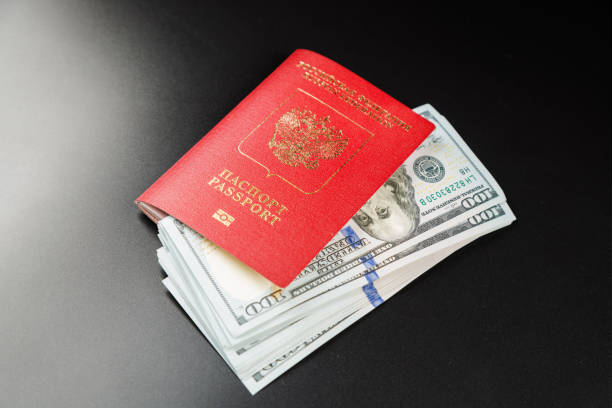istock russian international passport with inserted US dollars on black background 1396761610
