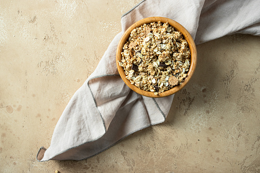 Wooden bowl with mix of unprocessed whole grains, chia, quinoa, nuts, seeds with chocolate .