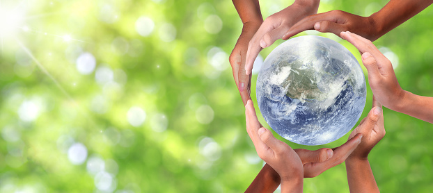 Conceptual symbol of multiracial human hands surrounding the Earth globe. Unity, world peace, humanity concept. World environment day- Earth Day concept.