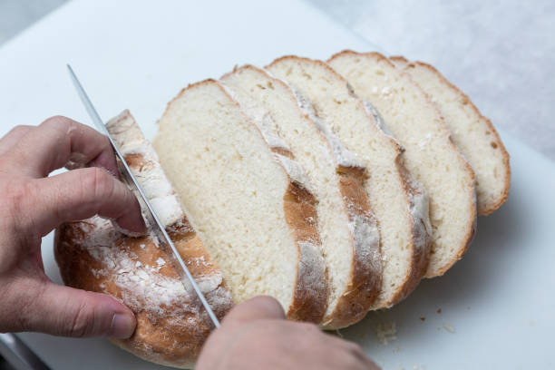 male hand cutting homemade bread