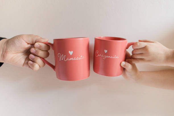 istock A Mother & Daughter's Hands Holding Matching Pink Mugs That Say 