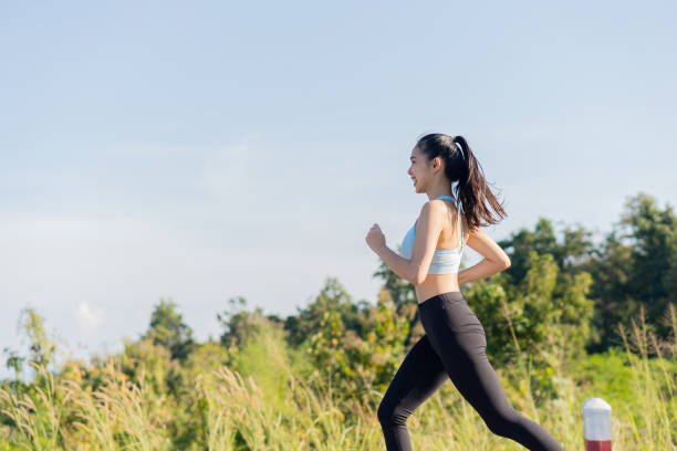 portrait d’une femme asiatique faisant de l’exercice en plein air dans un parc, elle fait du jogging pour sa santé. - run down photos et images de collection