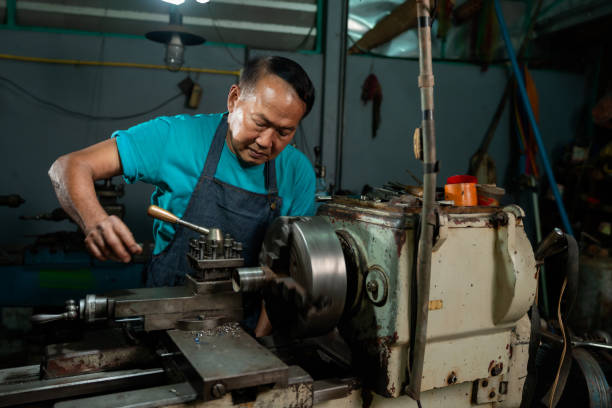 istock A senior craftsman who is skilled in craftsmanship, is controlling, skillfully operating a lathe, is in a small factory that is his family business. 1396774312