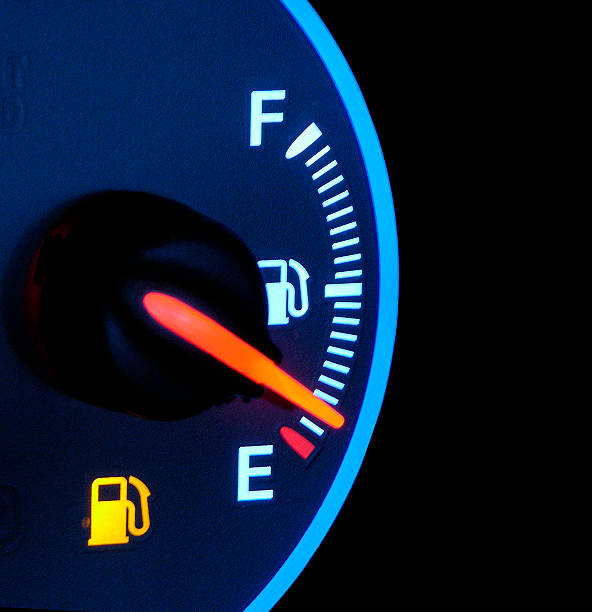 Out Of Gas A closeup of a car gas gauge. Focus is soft. Background is black with space for text on right. Great for concept of out of gas or gas prices. fuel prices photos stock pictures, royalty-free photos & images