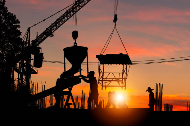 istock Silhouette of Foreman and worker team at construction site with blurred sunset sky background 1396776921