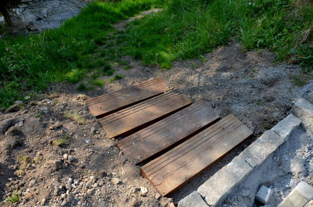 ristrutturazione di un pozzo con riparazione di un tetto fatto di tegole bruciate. un piccolo edificio in mattoni dall'aspetto gorico. scavare il terreno e riparare la facciata, - shingle bank foto e immagini stock