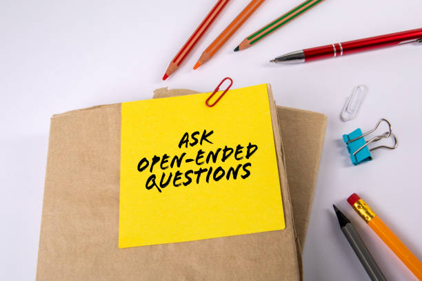 istock ASK OPEN-ENDED QUESTIONS. Stack of books on a white office desk 1396778366