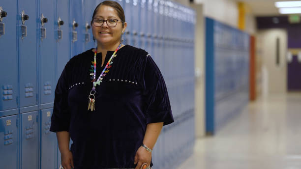Indigenous Navajo Cheerful teacher portrait at a school corridor
