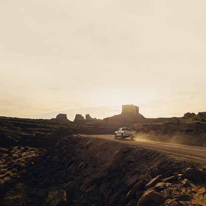 Pickup Truck speeding on a dirt road at sunset near to Moab park, Utah