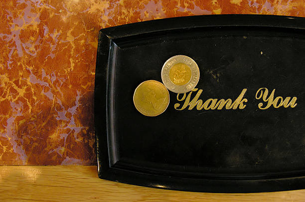 Tip plate. "Thank You" tip plate with $2 and $1 Canadian coins on it. loonies and toonie stock pictures, royalty-free photos & images