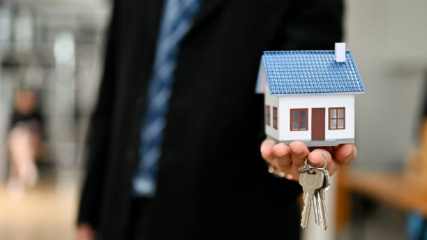 istock A house model mockup on a businessman's hand with blurred background. 1396783873