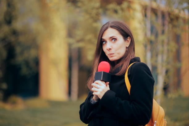 istock Funny Shy Journalist Holding a Microphone in Live Broadcast 1396783916