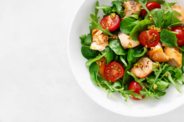 istock Grilled salmon salad with tomato and salad mix. Top view 1396786848
