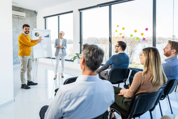 istock Young CEO talking to his colleagues while giving a business presentation on whiteboard in the office. 1396787723