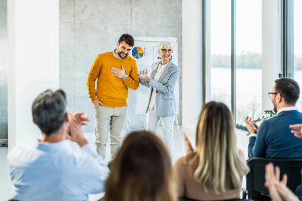 Large group of happy business people applauding and congratulating a young man. stock photo