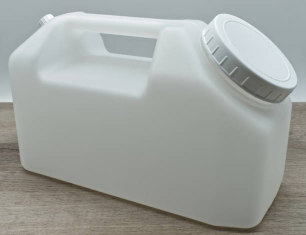 istock Urine collection container isolated on wooden table 1396789287