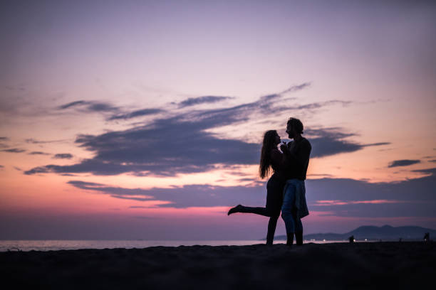 istock Romantic couple on the beach at dusk. 1396791488