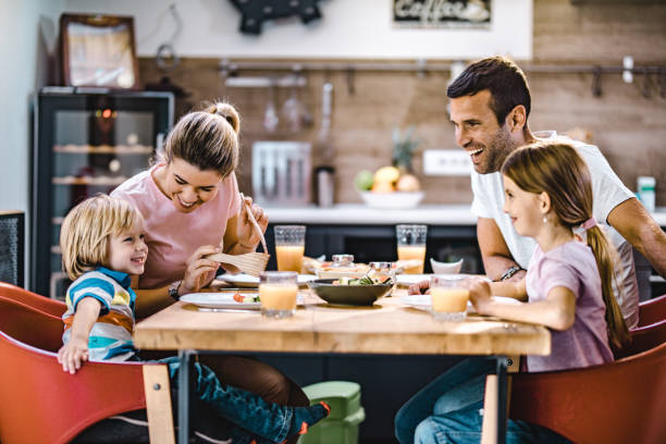 istock Young happy family talking during lunch at dining table. 1396791720