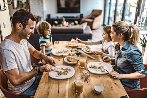 istock Happy family enjoying while having lunch in dining room. 1396791983