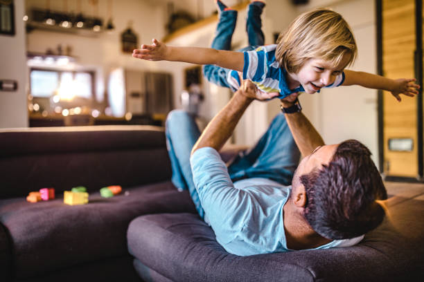 istock Joyful boy having fun while playing with his father at home. 1396793049