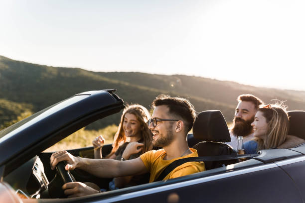 istock Young happy couples going on a road trip by convertible car. 1396793171