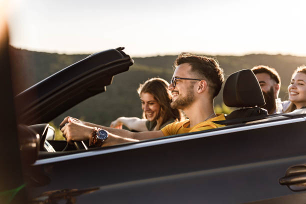 istock Group of happy friends having fun while going on a trip in a convertible car. 1396793206