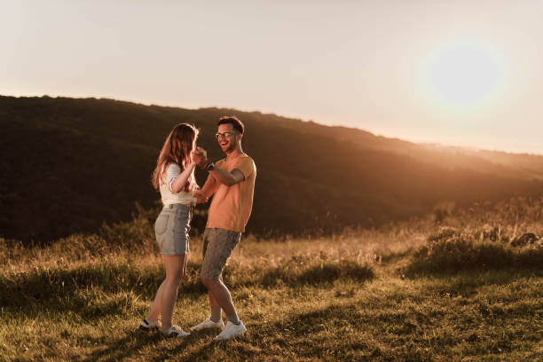 istock Young romantic couple enjoying in their dance during springtime at sunset. 1396793271