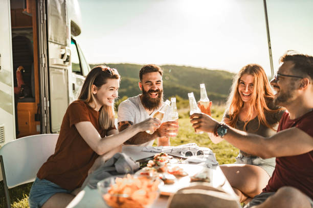 istock Cheerful friends toasting with beer on camping in nature. 1396793349