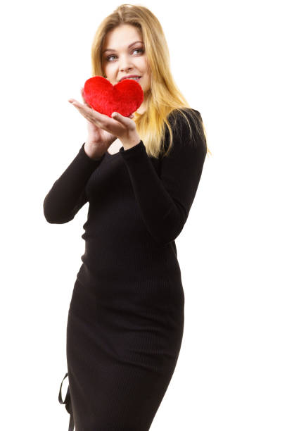 Romantic woman holding small red heart shaped fluffy pillow. Valentines day gift.