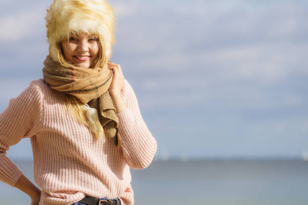 Winter fashion. Portrait positive teen girl in warm clothes. Happy young woman in fur hat doing fun isolated.