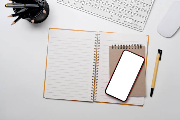 istock Mobile phone, notebook, pencil holder and wireless keyboard on white background. Top view. 1396799095