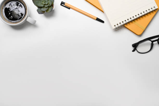 istock Notepad, glasses, coffee cup and succulent plant on white office desk. Flat lay. 1396799108