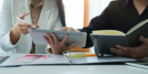 istock Cropped shot of young creative coworkers using digital tablet and discussing on new startup project together. 1396803225