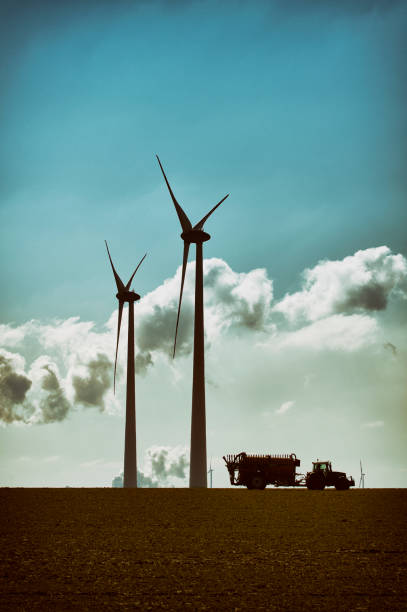 istock Two wind turbines and tractor with trailer 1396805262