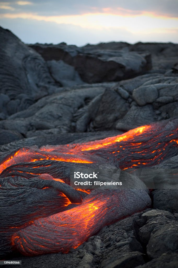 Molten lava flowing surrounded by cooled lava rock Flowing lava on Kona, the big island of Hawaii. Lava Stock Photo