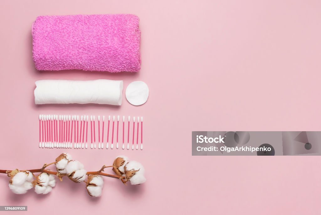 Spa concept. Flat lay background with cotton branch, cotton pads, eared sticks, pink towel. Cotton Cosmetic Makeup Removers Tampons. Hygienic sanitary swabs on the pink background Top view copy space Spa concept. Flat lay background with cotton branch, cotton pads, eared sticks, pink towel. Cotton Cosmetic Makeup Removers Tampons Hygienic sanitary swabs on the pink background Top view copy space Backgrounds Stock Photo