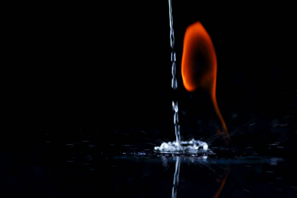 Shape of a fire burning. Orange flame on black background. Spring of water from above is extinguishing the flames.