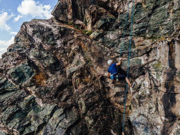 istock Man on the rock, using all his strength, climbing to the top. 1396813323