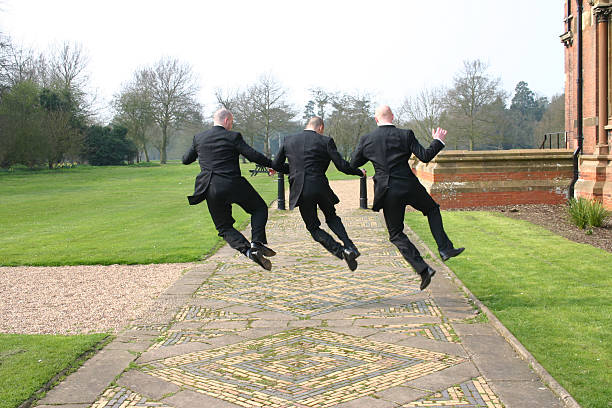3 men in suits jumping for joy
