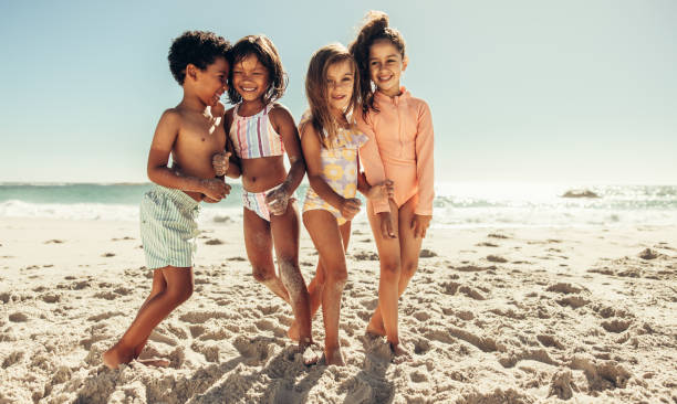 istock Happy kids playing together at the beach 1396815246
