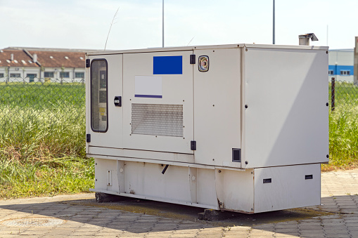 Stand By Electrical Power Generator Behind Industrial Building