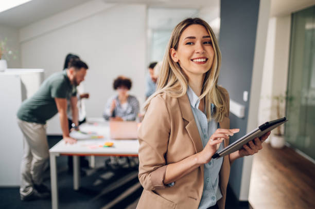 femme d’affaires posant et souriant lors d’une réunion dans un bureau - 30 34 ans photos et images de collection