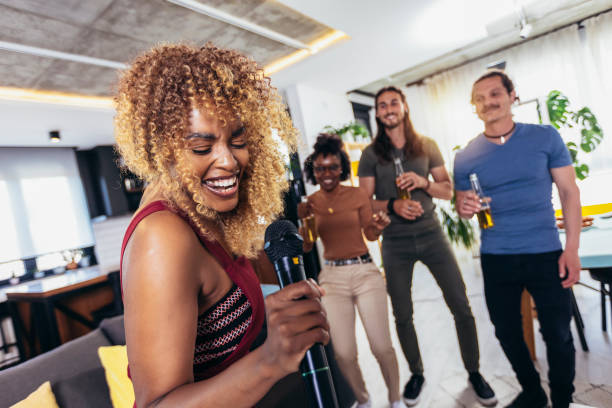 istock Group of young multicultural friends having party singing song using microphone at home. 1396819884