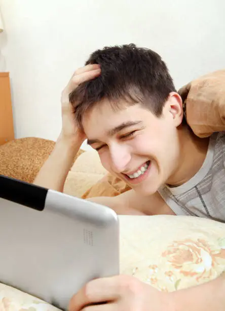 Cheerful Teenager with Tablet Computer at the Home