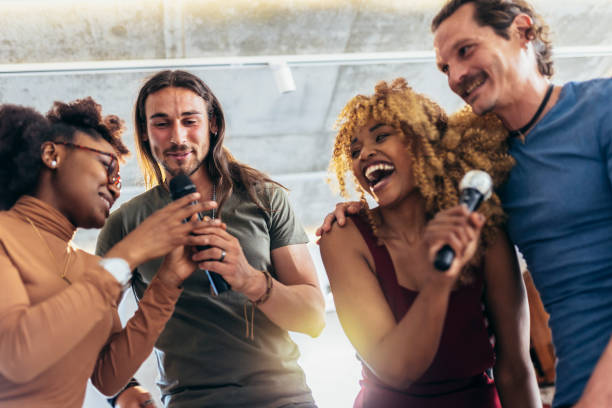 istock Group of young multicultural friends having party singing song using microphone at home. 1396821504