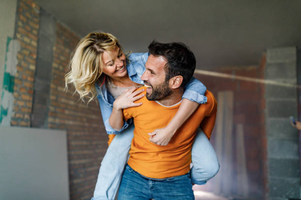 istock Carefree couple having fun while piggybacking at construction site. 1396822974