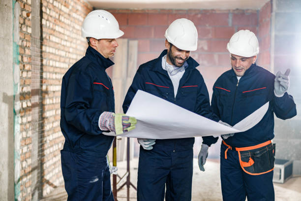 istock Team of manual workers examining housing project while working at construction site. 1396823428