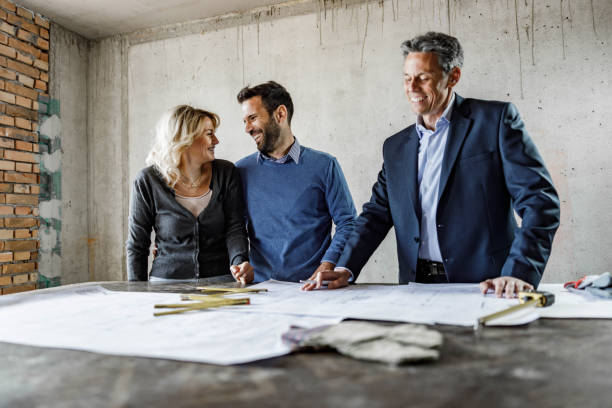 istock Happy couple talking while being at construction site with their architect. 1396824040